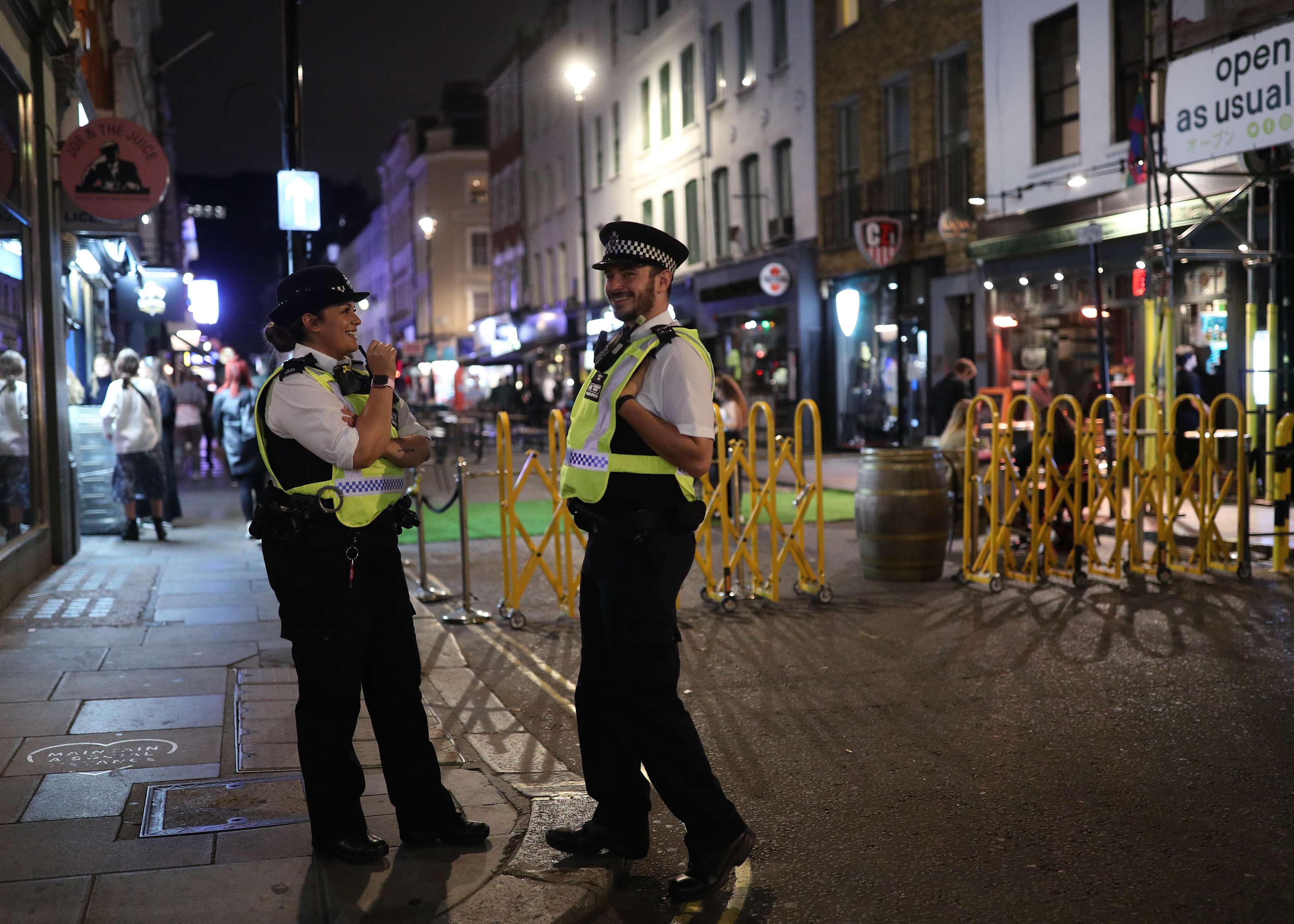 Police officers patrol Old Compton Street in Soho, London, after the announcement of a 10 p.m. curfew becoming effective Sept. 24.
